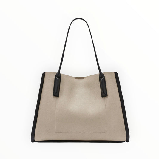 Triple H Treasures DKNY beige canvas tote bag with black leather accents and handles.